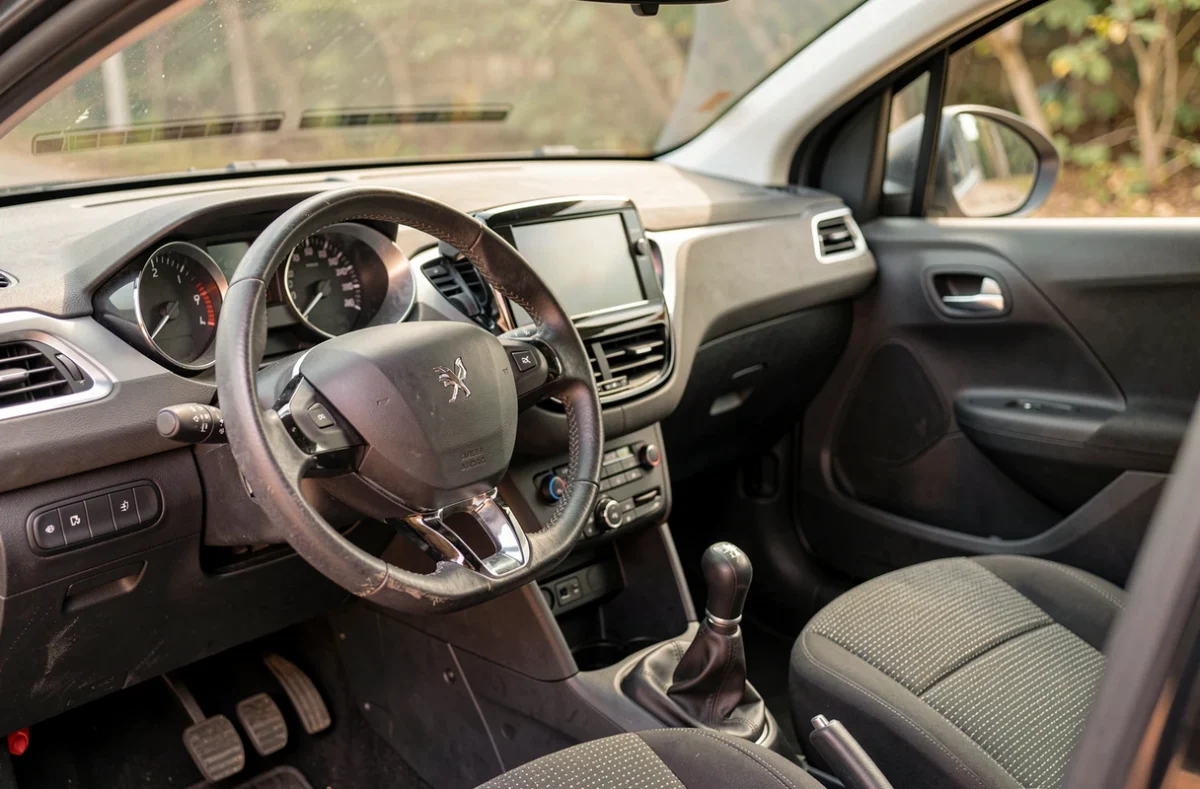 Intérieur de la Peugeot 208 VTi avec tableau de bord, volant et console centrale en gros plan