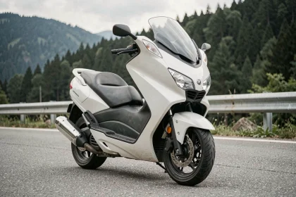 Yamaha TMAX 750 garé sur une route de montagne, vue 3/4 avant mettant en valeur le design musclé du maxi-scooter